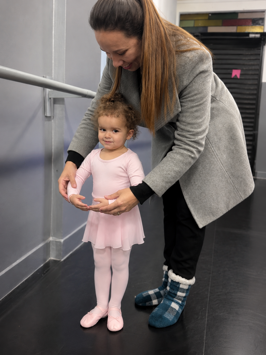 Professora da SEMIE Arte orientando com carinho uma pequena bailarina em seus primeiros passos